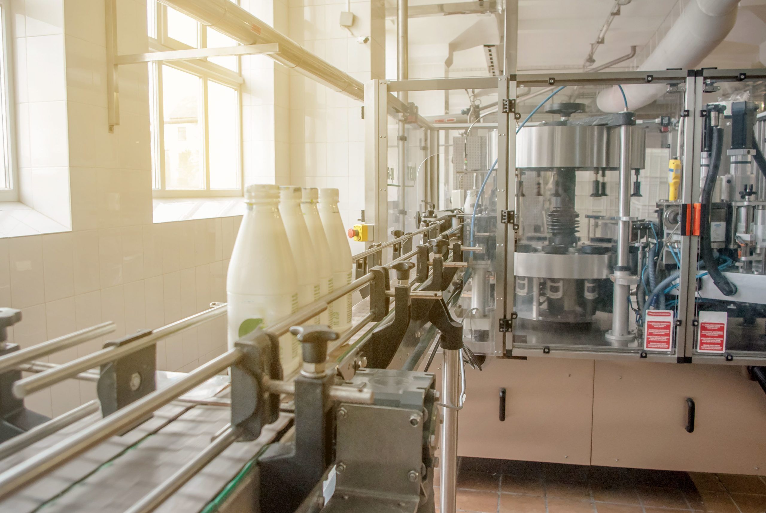 Conveyor belt with white milk bottles | Parsec Automation Corp.